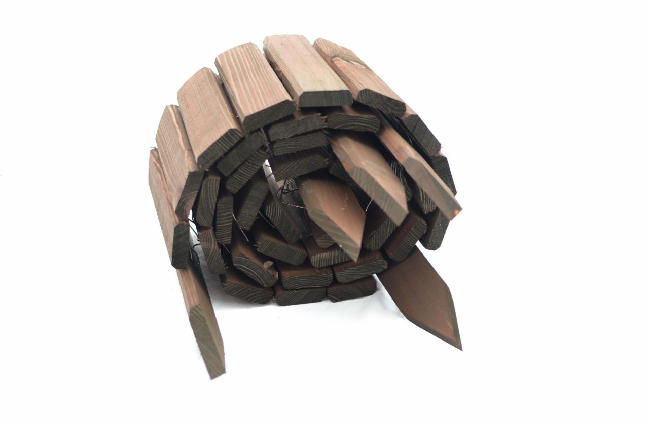 Rolka drewnianego obrzeża ogrodowego z palikami, widoczne sęki i usłojenie drewna, na białym tle.