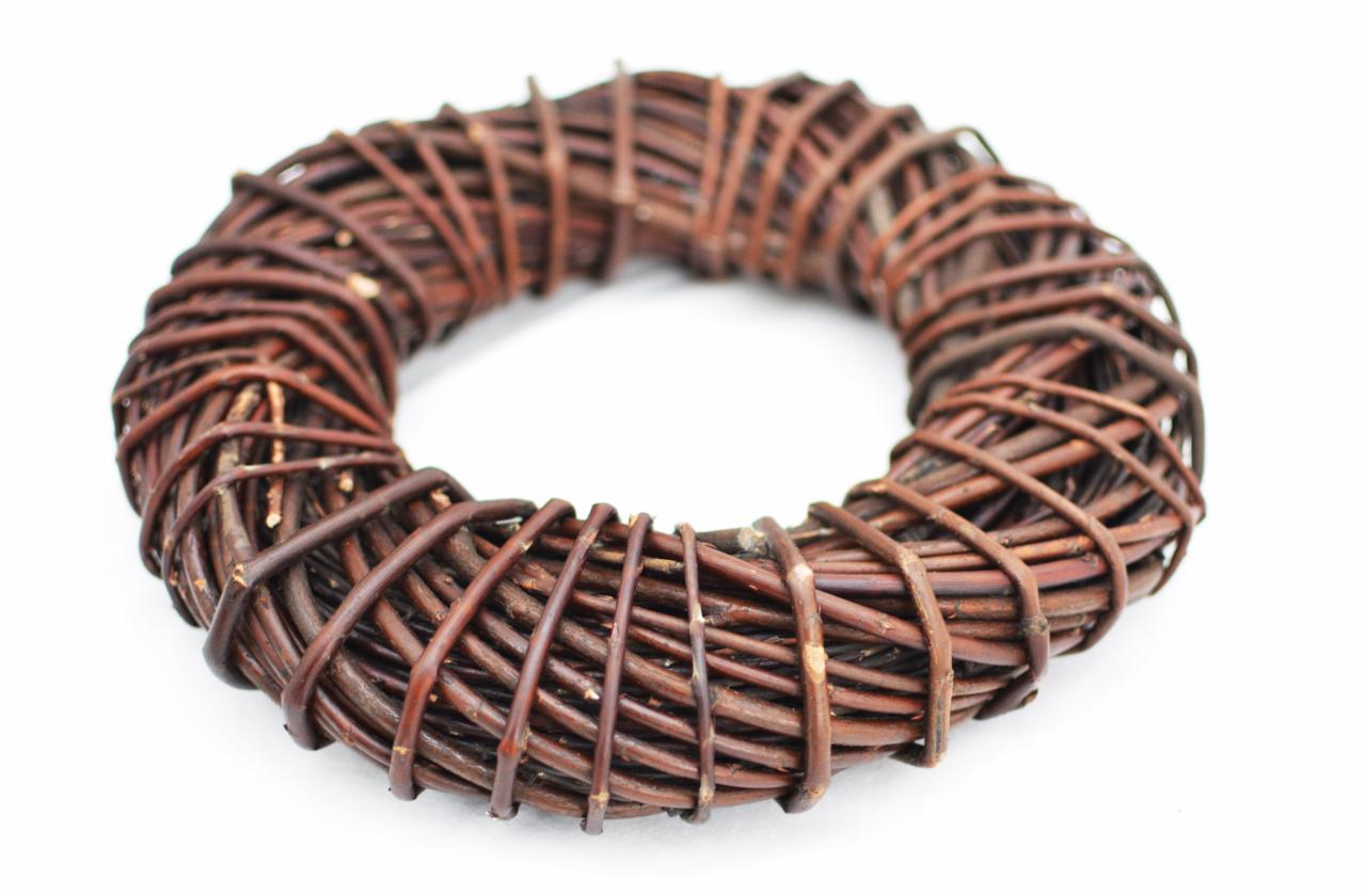 Wieniec z brązowych, cienkich gałązek na białym tle, o wyraźnej strukturze i widocznych sękach.