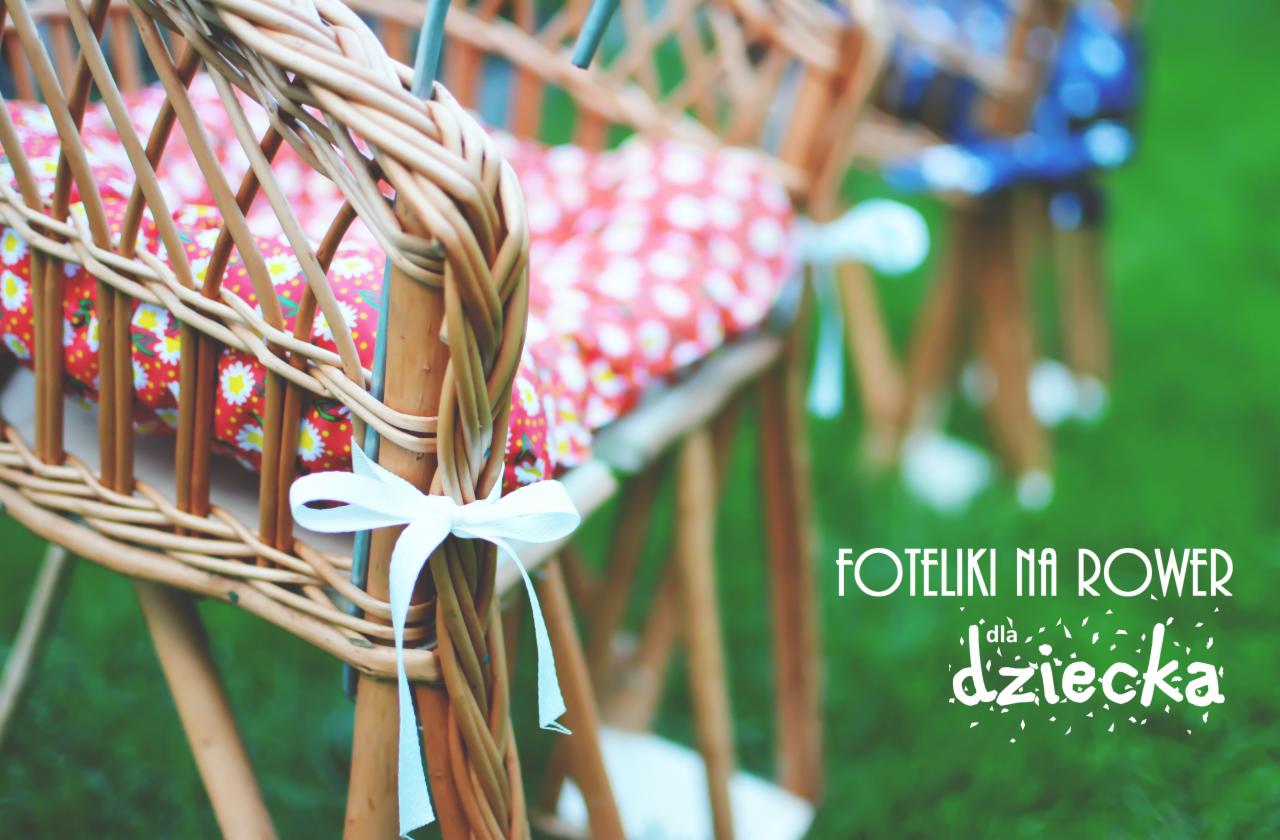 Ręcznie robione wiklinowe krzesełko dziecięce z poduszką w kwiaty, zawiązane białą wstążką, na tle zielonej trawy.