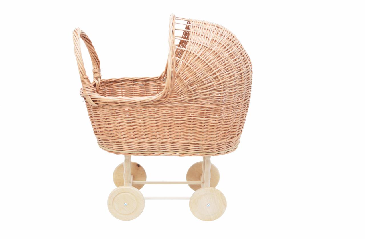 Ręcznie pleciony wózek dla lalek z wikliny, osadzony na drewnianych kółkach, na białym tle.