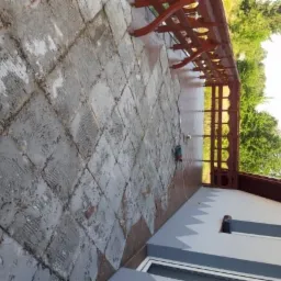 Demontaż starej terakoty na balkonie przy użyciu szlifierki kątowej; widoczne ślady po kleju i nierówności podłoża.