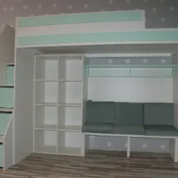 Wielofunkcyjny pokój dziecięcy: białe łóżko piętrowe ze schodami z szufladami, regałem i sofą z zielonym obiciem, na tle ściany w szare gwiazdki.