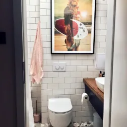 Nowoczesna łazienka z mozaikową podłogą, białymi płytkami na ścianach i plakatem Chewbacca-surfera w czarnej ramie.