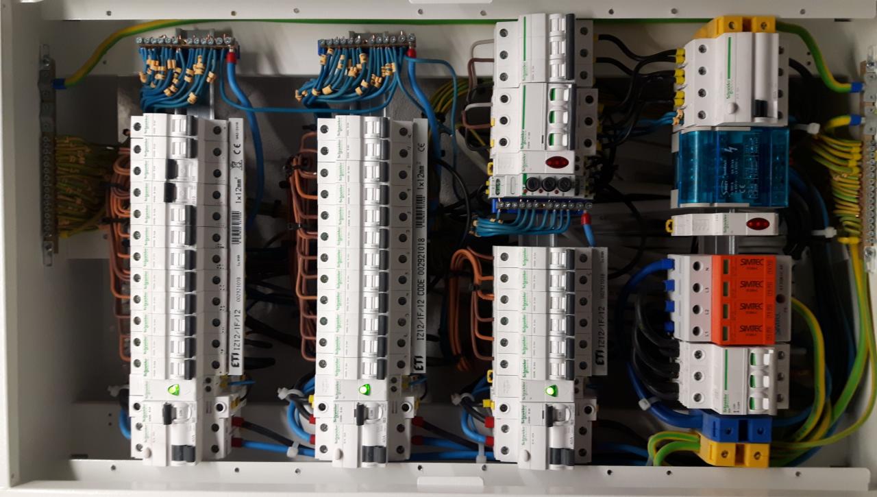 Rozdzielnica elektryczna z widocznymi bezpiecznikami, przewodami i listwami zaciskowymi, zainstalowana przez fachowca we Wrocławiu.