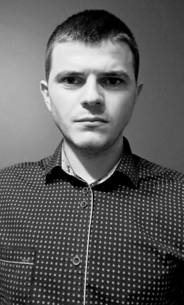 Portret mężczyzny w koszuli w kropki, czarno-białe ujęcie z bliska.