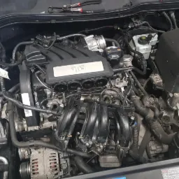 Silnik 1.6 w trakcie naprawy w Dębem Wielkim, widoczne narzędzia i elementy instalacji.