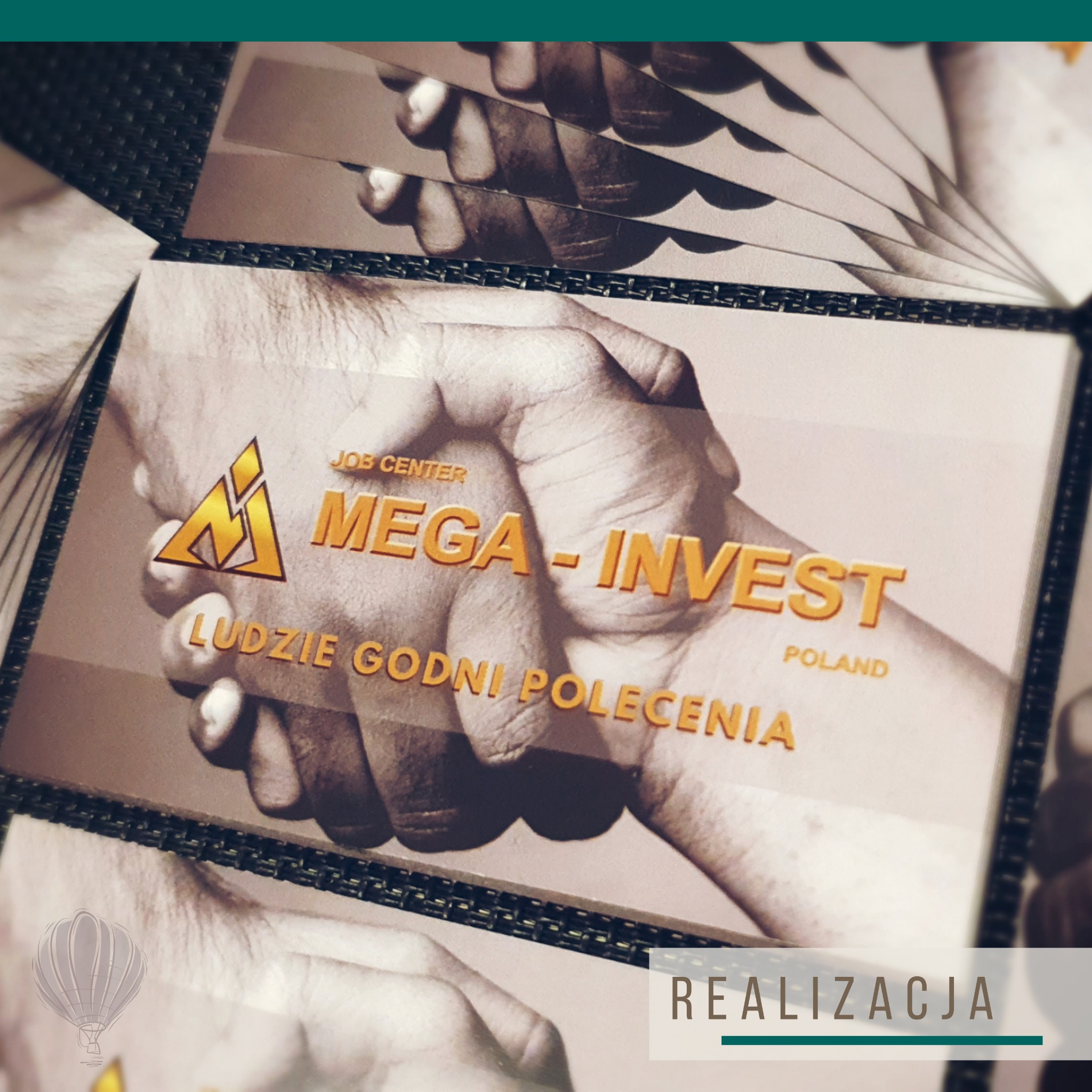 Stos wizytówek firmy Mega-Invest z motywem dłoni i złotym logo na czarnym tle, ułożonych kaskadowo.