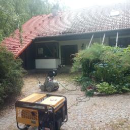 Wash-King Malowanie dachów Łukasz Biernat - Dom z częściowo oczyszczonym dachem, widoczny generator prądu i myjka ciśnieniowa na podwórku.