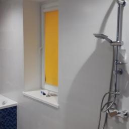 CLEAN MASTER BY TRUST TREE - Wykończona łazienka z chromowaną baterią prysznicową, białymi płytkami ściennymi, drewnopodobną podłogą i oknem z żółtą roletą w Rybnicy.