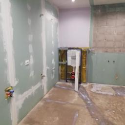 CLEAN MASTER BY TRUST TREE - Remont łazienki w Rybnicy: montaż stelaża podtynkowego Grohe na tle surowych ścian z płyt karton-gips, widoczne instalacje wodne i elektryczne przed dalszymi pracami wykończeniowymi.