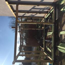 CLEAN MASTER BY TRUST TREE - Konstrukcja drewniana altany ogrodowej w trakcie budowy, widoczne elementy szkieletu, niepomalowane deski, błękitne niebo w tle.