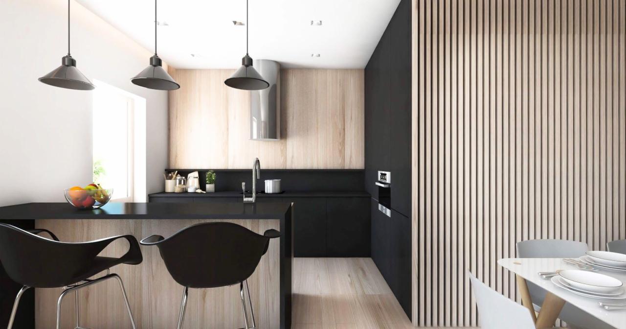 Nowoczesna kuchnia z czarnymi szafkami, drewnianymi panelami ściennymi i wyspą z czarnym blatem oraz designerskimi krzesłami barowymi, oświetlona trzema wiszącymi lampami w stylu industrialnym.