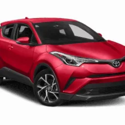 Czerwony samochód Toyota C-HR na białym tle, widok z przodu i lekko z boku, z wyraźnie widocznymi reflektorami i felgami.