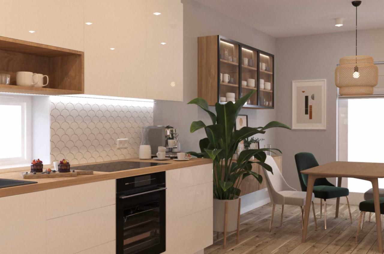 Jasna kuchnia z drewnianymi akcentami, mozaiką w kształcie rybich łusek na ścianie, czarną płytą indukcyjną i piekarnikiem, dekoracyjnym oświetleniem oraz rośliną doniczkową w minimalistycznej donicy.