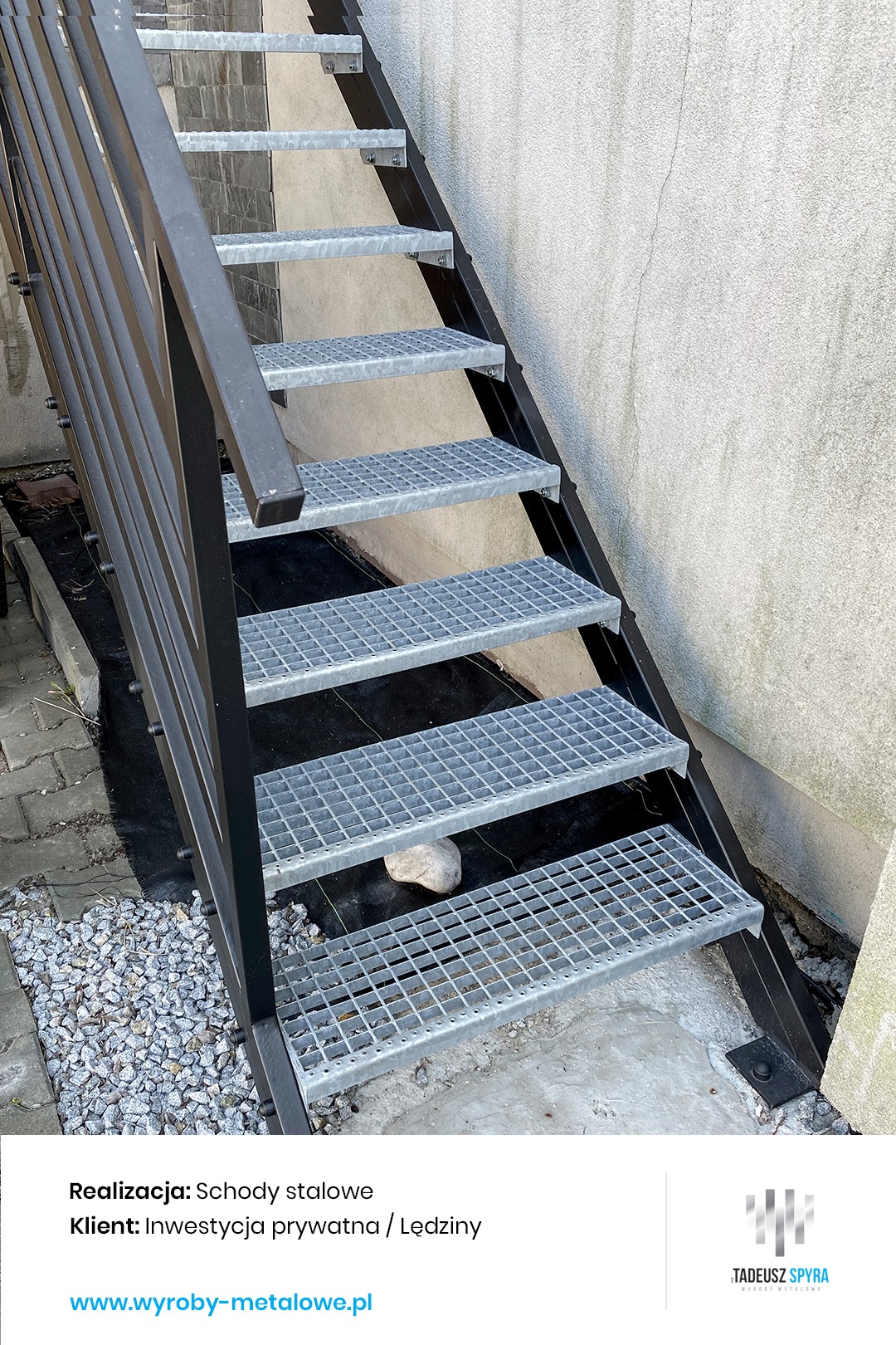 Zewnętrzne schody z metalową kratą, czarna poręcz, widok z dołu, kamień pod jednym ze stopni.