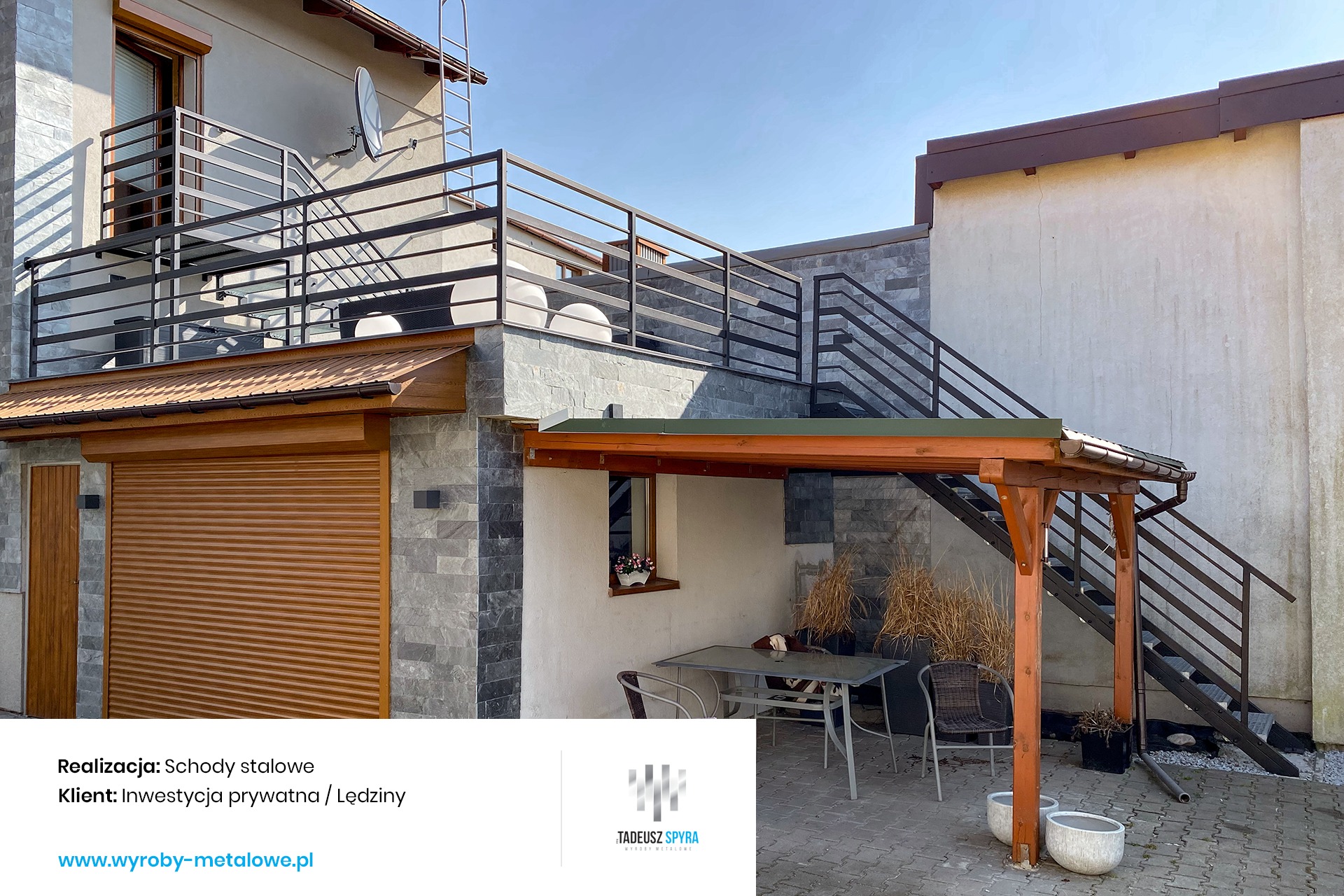 Zewnętrzne schody metalowe z balustradą, prowadzące na balkon i do ogrodu, z drewnianą altaną i garażem w tle, wykonane z ciemnego metalu o minimalistycznym designie.