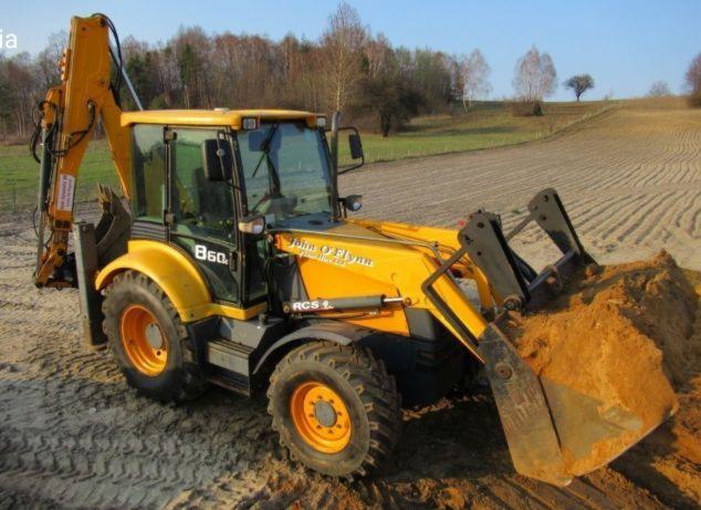 Żółta koparko-ładowarka John O'Flynn B60 z pełną łyżką piasku na polu uprawnym w słoneczny dzień.