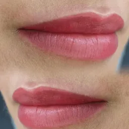 Zbliżenie na usta po zabiegu makijażu permanentnego z widoczną linią konturu i wypełnieniem kolorem w odcieniach różu.