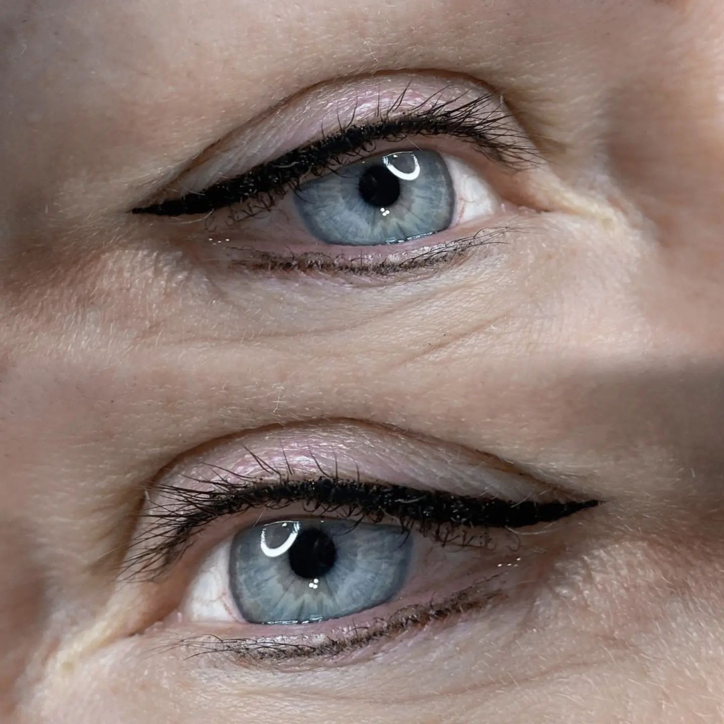 Zbliżenie na dwa błękitne oczy z precyzyjnie wykonanym czarnym eyelinerem, podkreślającym linię rzęs.
