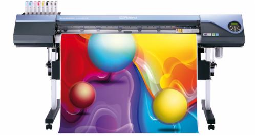 Drukarka wielkoformatowa Roland z wydrukiem abstrakcyjnym motywem kul w kolorach czerwonym, żółtym i niebieskim na białym tle.