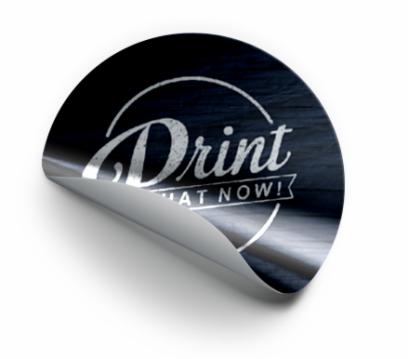 Okrągła naklejka z częściowo odklejonym rogiem, na czarnym tle imitującym drewno, z białym napisem 'Print IT NOW!' w ozdobnej czcionce.