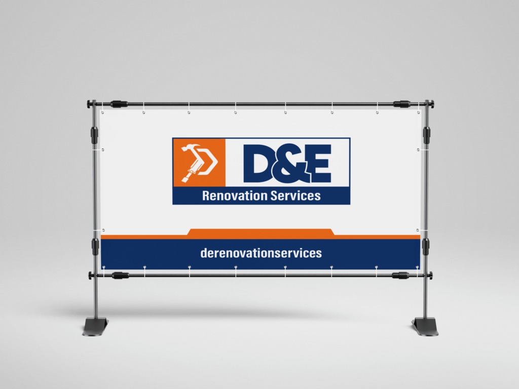 Baner reklamowy firmy D&E Renovation Services z pomarańczowo-białym logo przedstawiającym młotowiertarkę w pomarańczowym kwadracie i nazwą firmy na białym tle z granatowym paskiem u dołu...