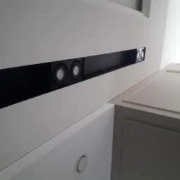 Biała zabudowa sufitowa z wpuszczonymi punktowymi lampami LED, widok z dołu, realizacja w Gdańsku.