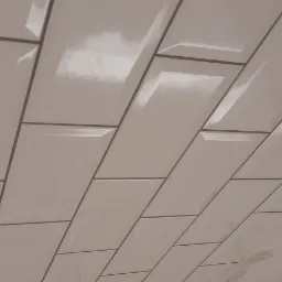 Ułożone, błyszczące, białe płytki typu metro z ciemną fugą na ścianie, widok pod kątem, w tle niedokończona ściana w Przystajni.