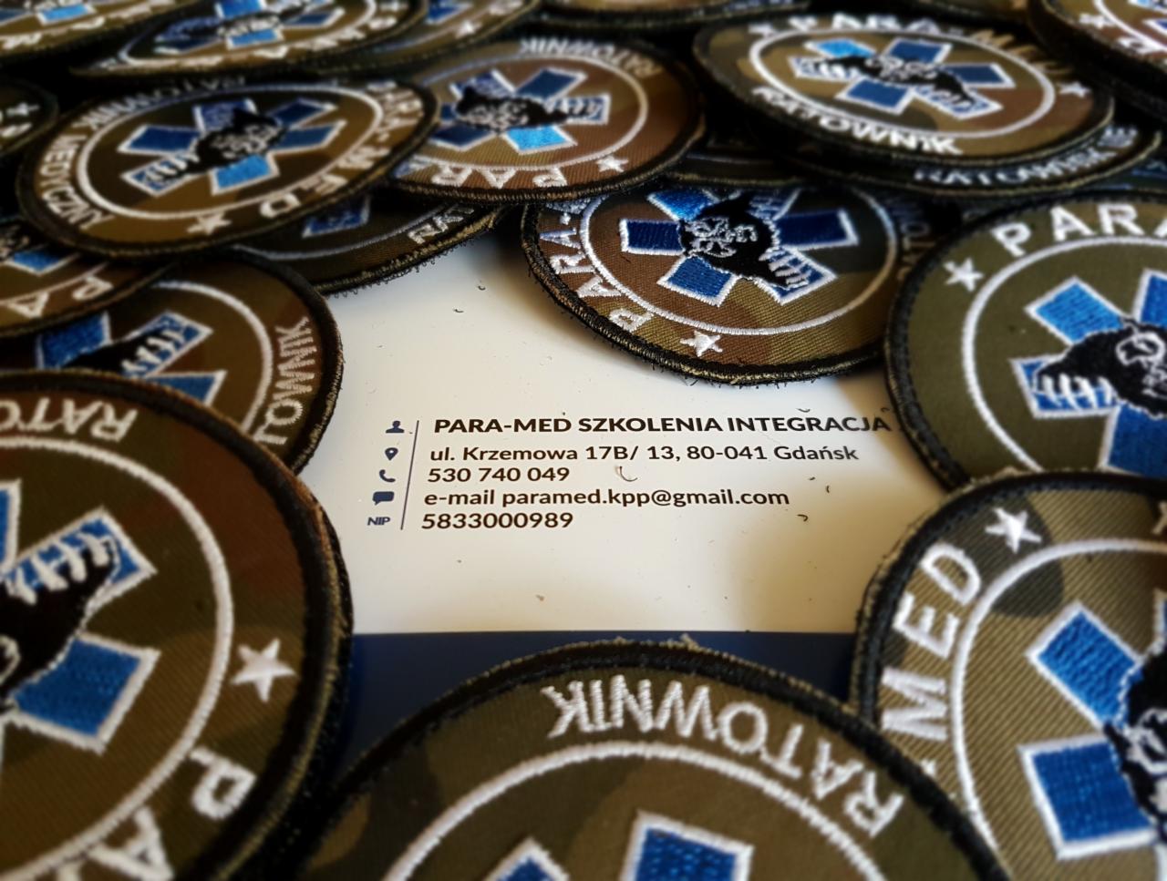Naszywki ratownicze z logo firmy PARA-MED SZKOLENIA INTEGRACJA i danymi kontaktowymi na wizytówce.