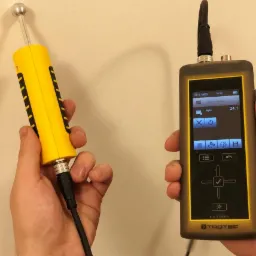 Pomiar wilgotności ściany za pomocą elektronicznego wilgotnościomierza marki Trotec, z widocznym wskazaniem 24.1 na wyświetlaczu.