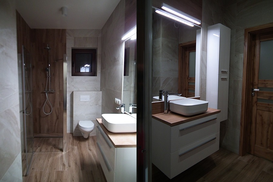 Nowoczesna łazienka z drewnopodobnymi płytkami, kabiną prysznicową typu walk-in, białą umywalką nablatową na szafce z drewnianym blatem oraz lustrem z oświetleniem LED.