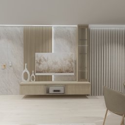 Dolecińska Projekt DARIA DOLECIŃSKA - Jasne wnętrze z telewizorem, dekoracyjnymi wazonami i panelami ściennymi. Minimalistyczny design z elementami drewna i kamienia. Widoczne krzesła i stół.