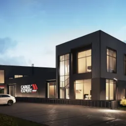 Nowoczesny budynek biurowy Cargo Expert Group z czarną elewacją i dużymi oknami, oświetlony wieczornym światłem, z zaparkowanymi samochodami na pierwszym planie.