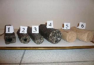 Przekrój poprzeczny brykietów opałowych o numerach od 1 do 6, prezentujących różnice w składzie i strukturze, ułożonych na białym blacie z brązowym obramowaniem.