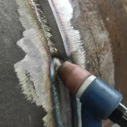 Spawanie rury metodą TIG, widoczna spoina z charakterystycznymi tęczowymi przebarwieniami i uchwyt spawarki KR20HC.