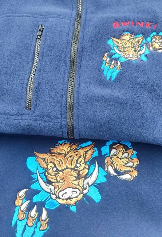 Granatowa bluza polarowa z zamkiem błyskawicznym i haftowanym motywem dzika z pazurami w turkusowej obwódce.