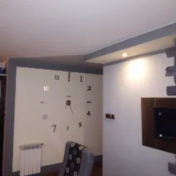 Ściana w salonie z dużym zegarem naklejanym, fragmentem ściany wykończonej kamieniem dekoracyjnym i telewizorem w ramie.