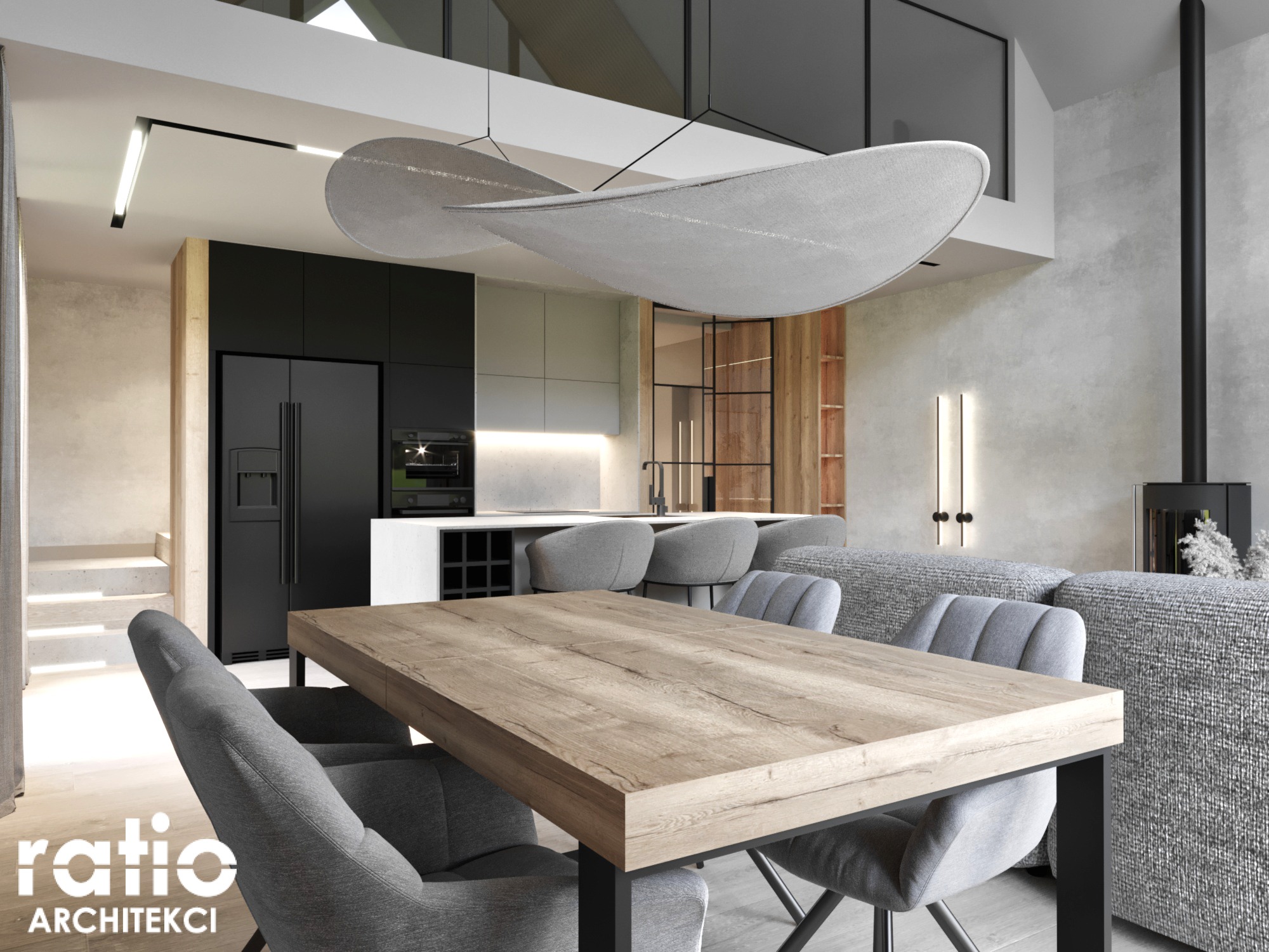 Wnętrze domu z drewnianym stołem jadalnym, szarymi krzesłami, sofą w odcieniach szarości oraz designerską lampą sufitową w kształcie liścia, w tle widoczna kuchnia z czarną lodówką i drewnianymi...