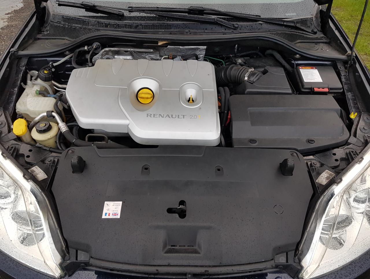 Otwarta maska samochodu Renault Megane z widocznym silnikiem 2.0T, srebrna pokrywa silnika z żółtym korkiem wlewu oleju, widoczne elementy instalacji elektrycznej i płynów eksploatacyjnych.