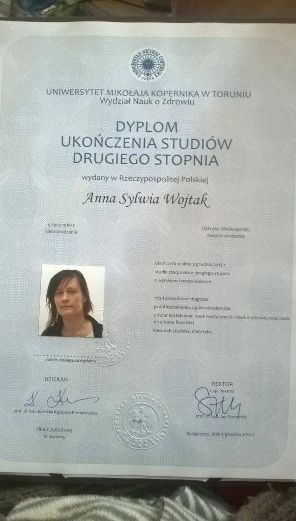 Skan dyplomu ukończenia studiów drugiego stopnia na Uniwersytecie Mikołaja Kopernika w Toruniu, wydany Annie Sylwii Wojtak, kierunek studiów: dietetyka, z pieczęciami i podpisami Dziekana i Rektora.