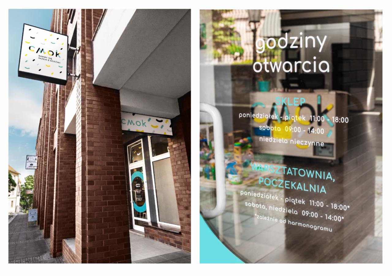 Zewnętrzny szyld sklepu i warsztatowni dla dzieci 'CMOK' w Poznaniu, widoczny na tle ceglanej elewacji budynku, z informacją o godzinach otwarcia na witrynie. Szyld z kolorowymi elementami...