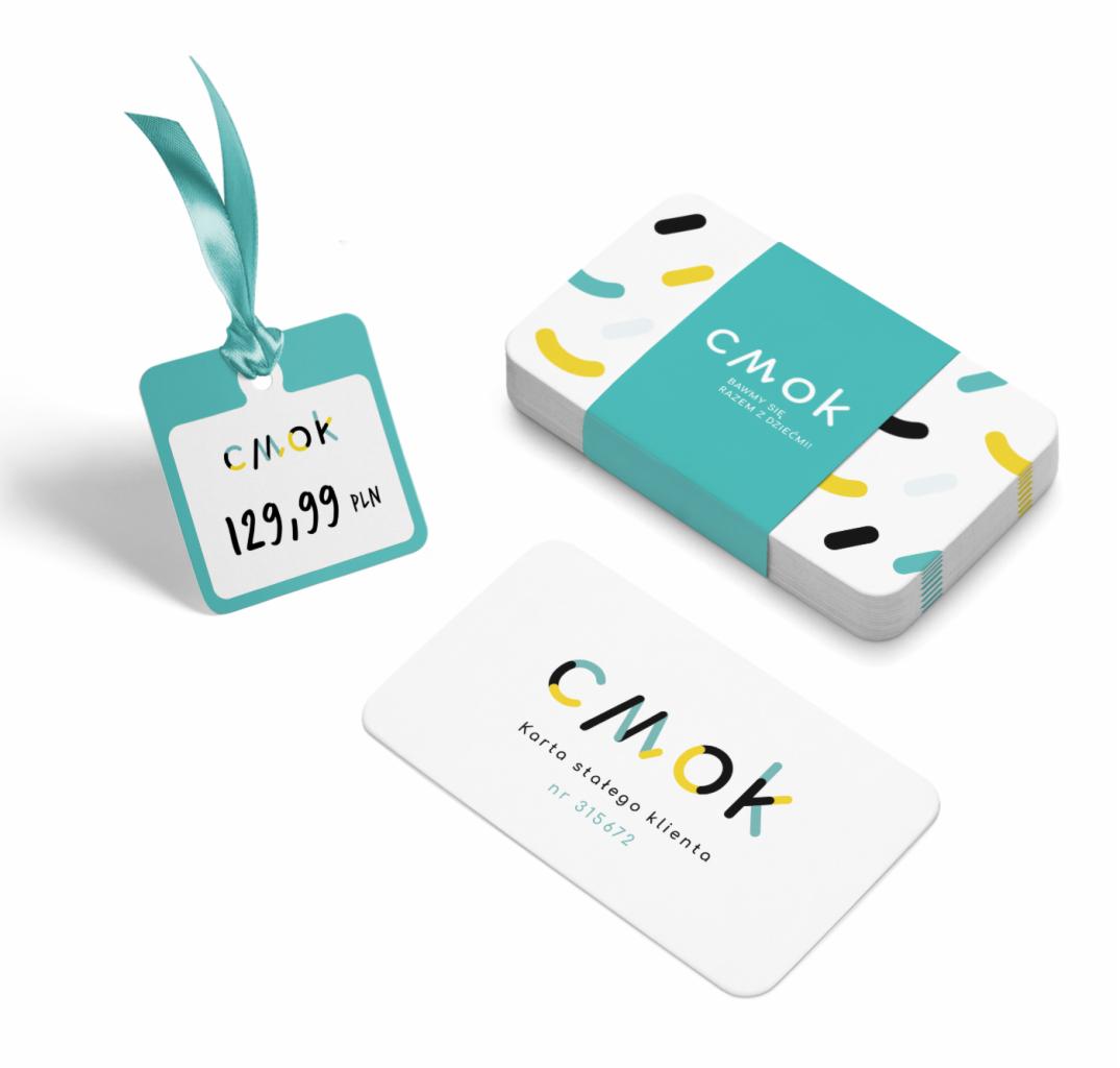 Zestaw materiałów firmowych: zawieszka cenowa z turkusową wstążką, wizytówki i karta stałego klienta z logo 'CMOK' na białym tle.