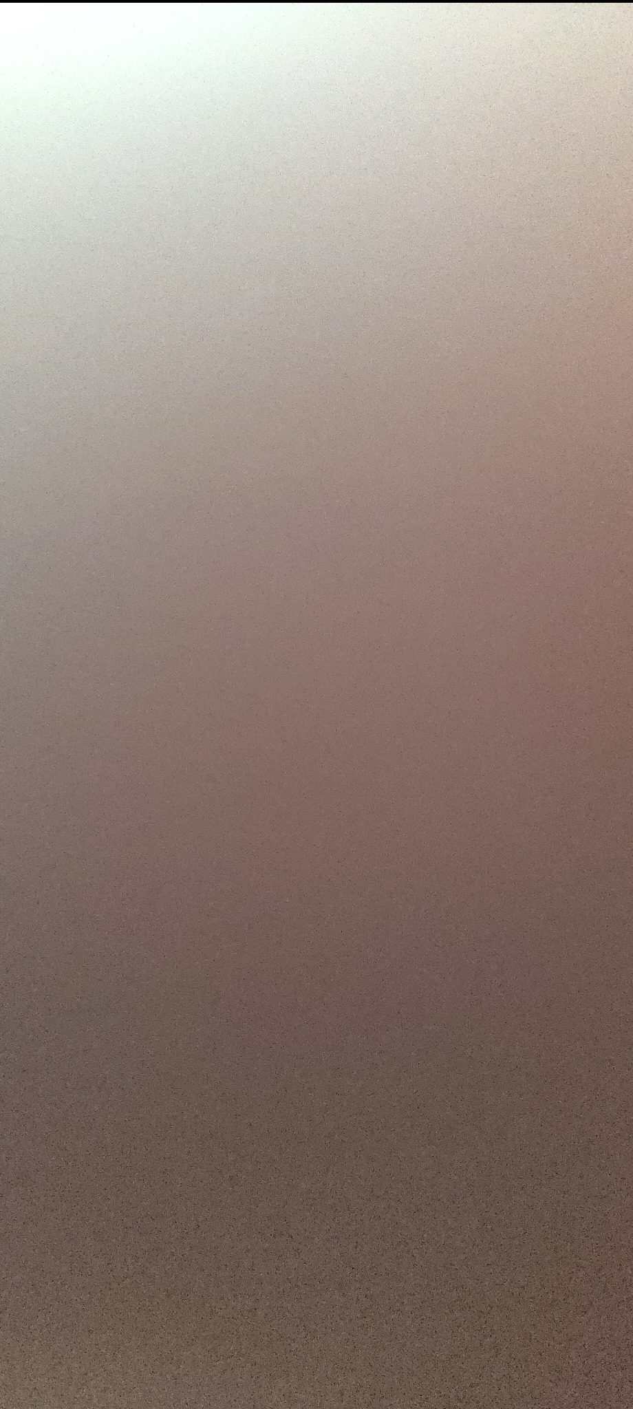 Gładka, jednolita powierzchnia tynku w odcieniach beżu i brązu, z delikatną fakturą, ukazująca równomierne nałożenie i wykończenie. Gradient światła od góry.