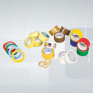 Zestaw różnokolorowych taśm klejących w rolkach, ułożonych na jasnym, gradientowym tle, z widocznymi detalami faktury papieru i tworzywa sztucznego.