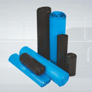 Zestaw rolek worków na śmieci w kolorach czarnym i niebieskim, ułożonych na jasnym tle z gradientem.