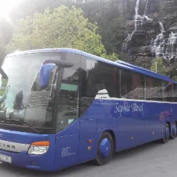 Niebieski autokar Setra z napisem 'Sophia Travel' na tle wodospadu i zieleni.