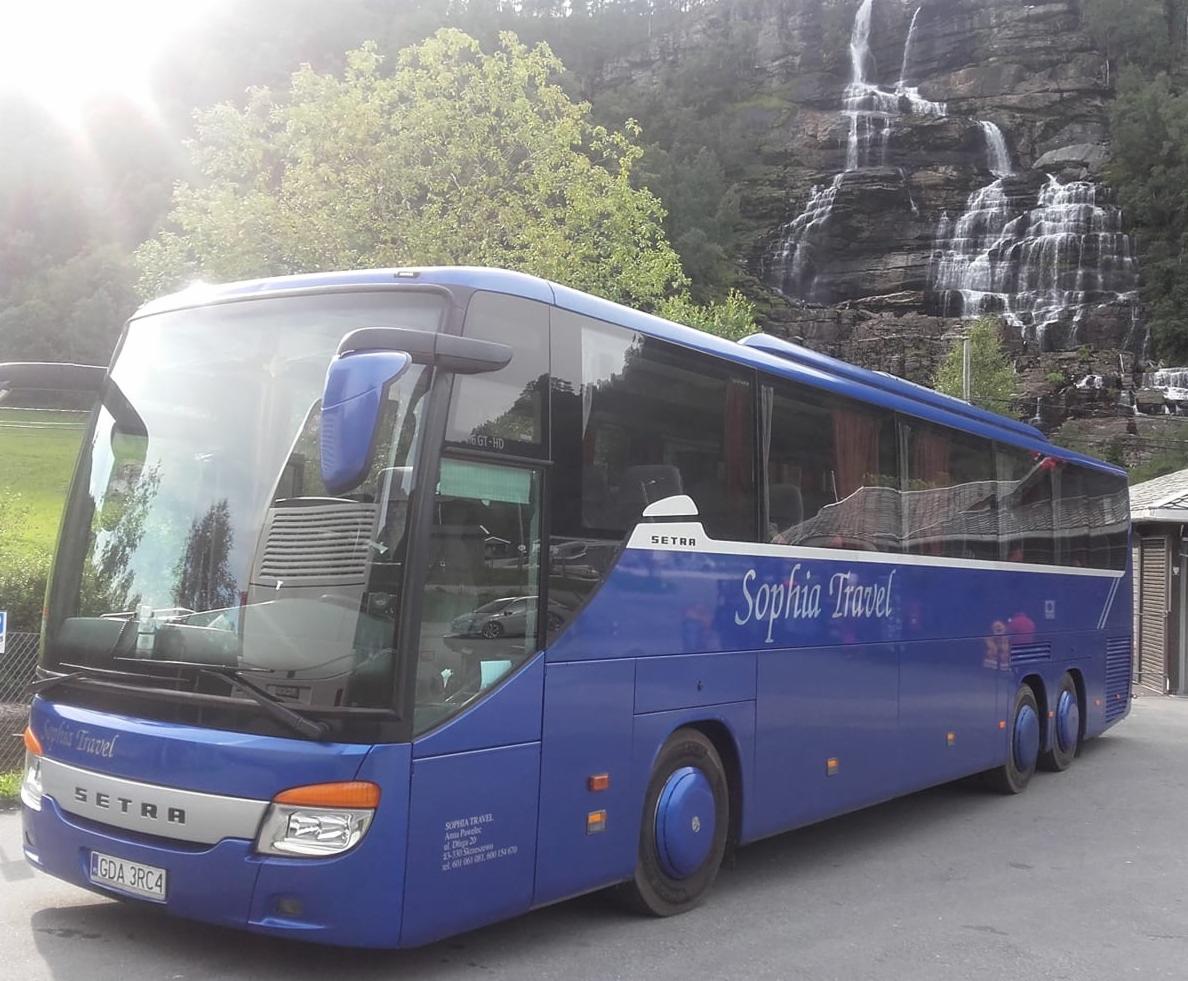 Niebieski autokar Setra z napisem 'Sophia Travel' na tle wodospadu i zieleni.