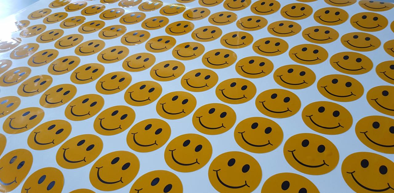 Arkusz z żółtymi, okrągłymi naklejkami z uśmiechniętymi buziami, wyprodukowany w Warszawie.