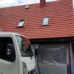 VERTEX EXPERT SPÓŁKA Z OGRANICZONĄ ODPOWIEDZIALNOŚCIĄ - Czerwony dach z dachówką karpiówką i oknami dachowymi, widoczny fragment białego samochodu dostawczego i zadaszone miejsce pracy, zabezpieczone folią.