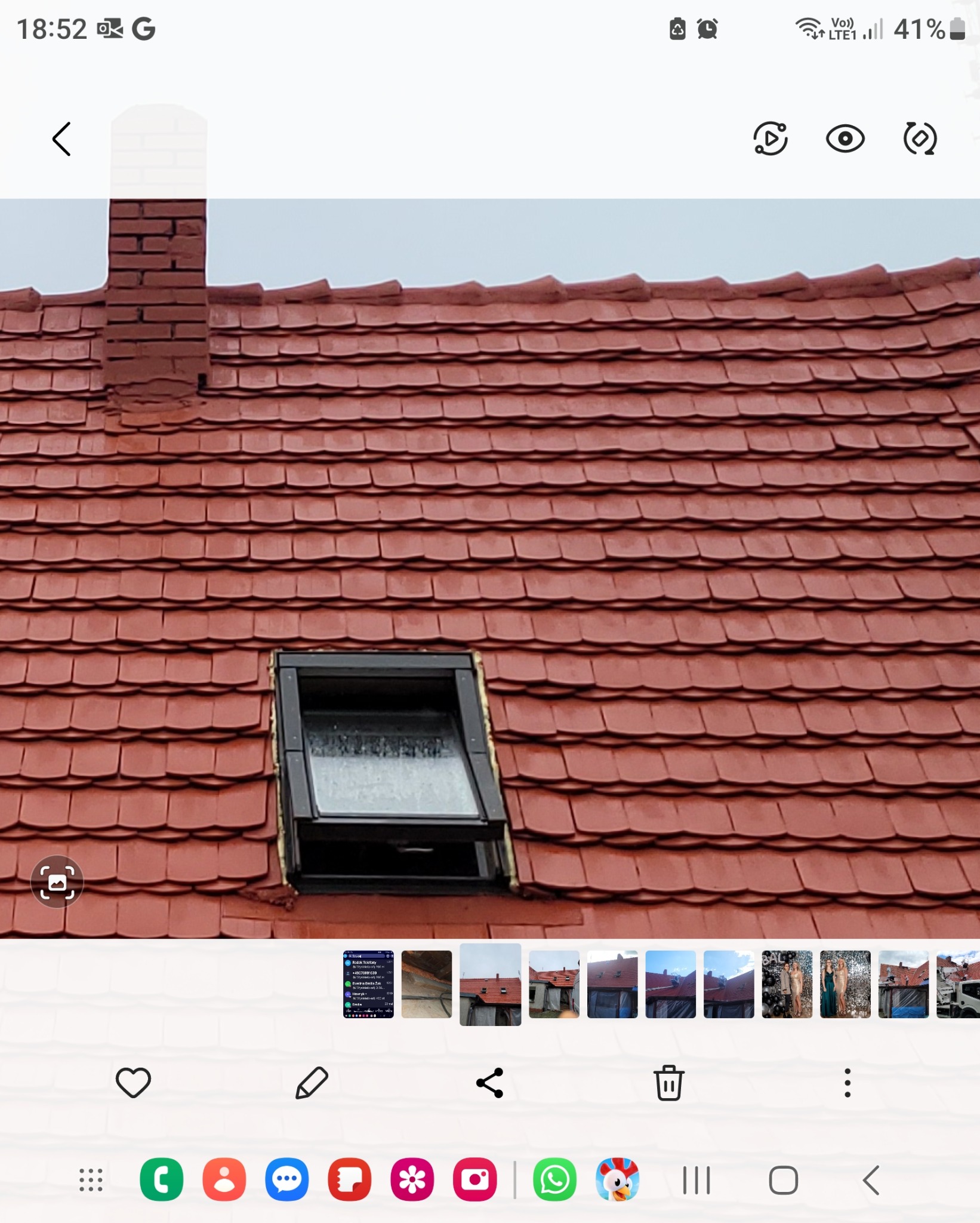 Czerwona dachówka karpiówka z kominem z cegły i oknem dachowym. Widok z dołu na skośny dach. Detal pokrycia dachowego po renowacji.